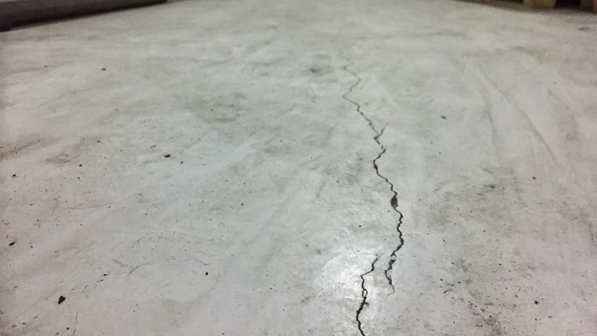 crack running along a gray concrete floor surface